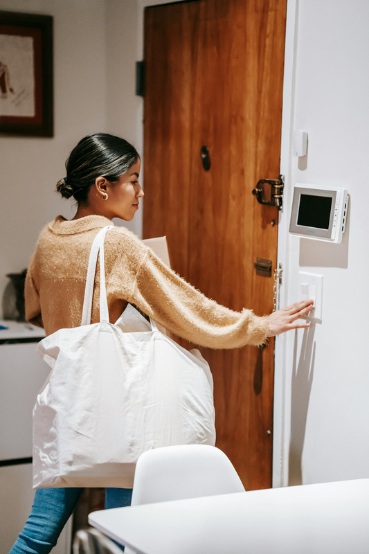 Hand adjusting a thermostat to COOL mode while troubleshooting an AC that won’t turn on