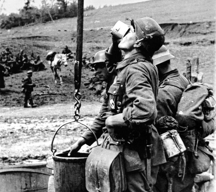 Солдаты вермахта пьют воду из колодца в Харьковской области. У солдата на переднем плане трофейный с