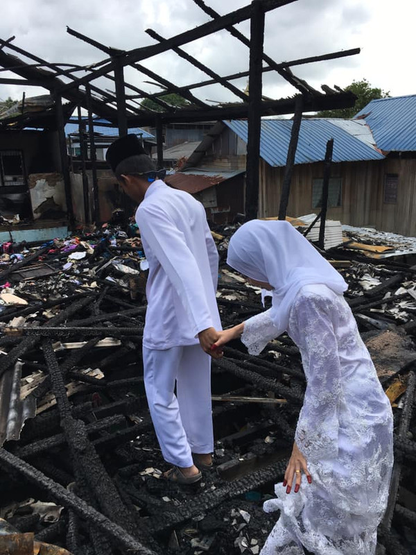 Sepasang pengantin melawat rumah mereka yang terbakar