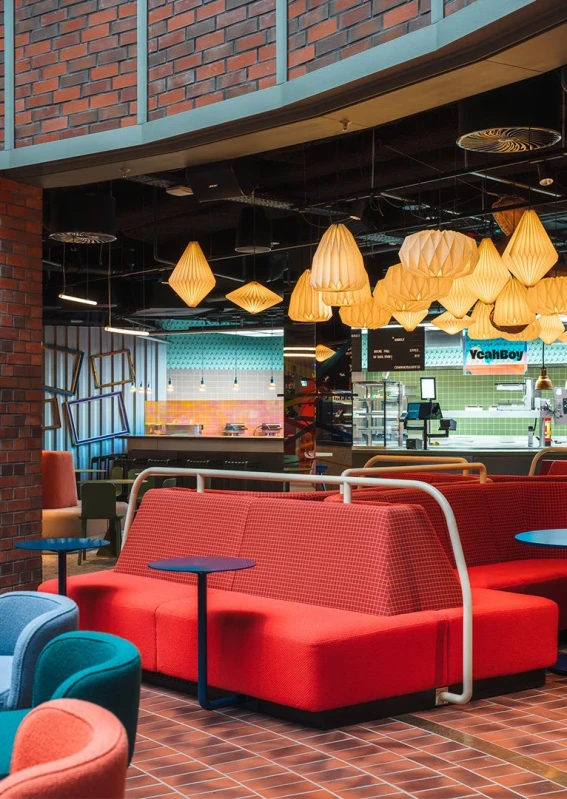 Shared food court seating beneath decorative lantern lighting at Le big TamTam in Hamburg