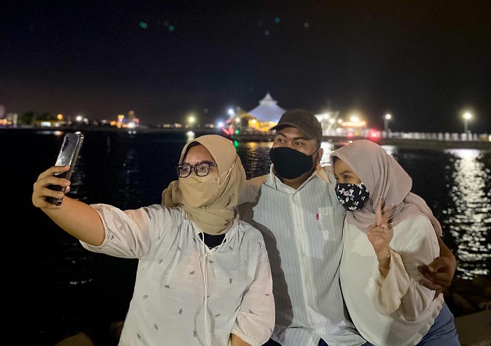Ilustrasi liburan ke Ancol saat malam hari.