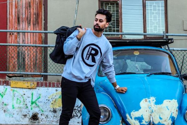 Muskarac u sportskoj odeci pored auta buba