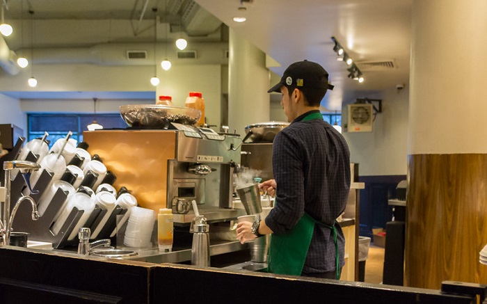 Barista Starbucks identik memakai celemek atau apron berwarna hijau yang ikonik.