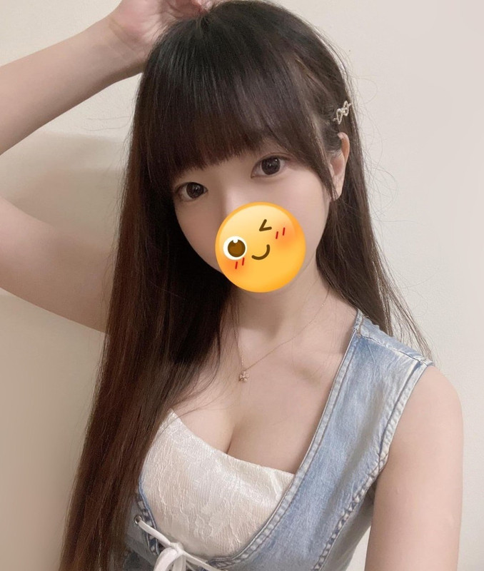 長髮瀏海女生穿淺色上衣與牛仔背心對鏡自拍