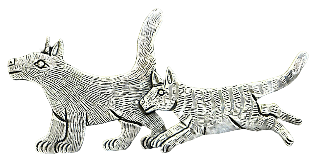 a silver broach/pin of two creatures which are supposed to be coyotes but look like an interesting cat-dog hybrid. the bigger one is in front, perhaps a mother to the other, and the smaller one runs to catch up
