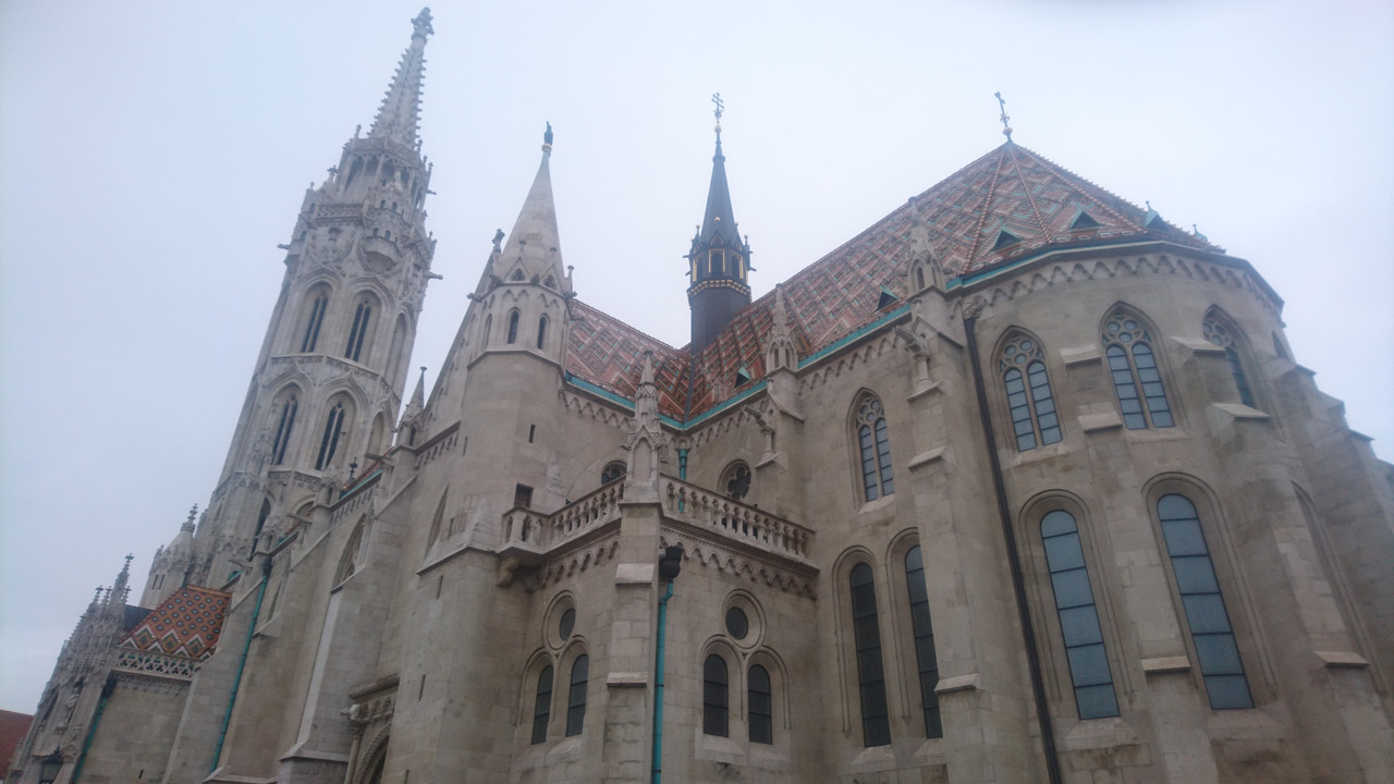 The side of the Mattias Church, you can see the tower on the left of the picture. At the front is the rest of the building. The roof, decorated with red, blue and yellow tiles, can be clearly seen.