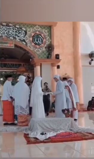 Mempelai pria dan wanita sedang membawa mahar