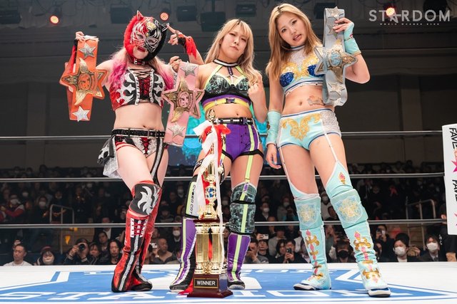 Photo from STARDOM of Starlight Kid, AZM, and Miyu Amasaki with the Artist Of Stardom titles and a trophy