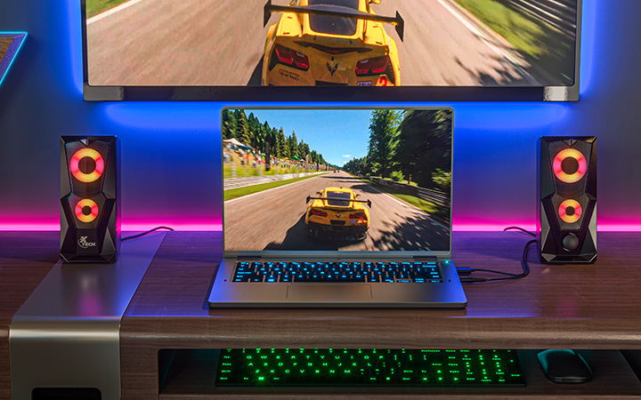Una persona utilizando las bocinas Xtech en su escritorio de gaming.