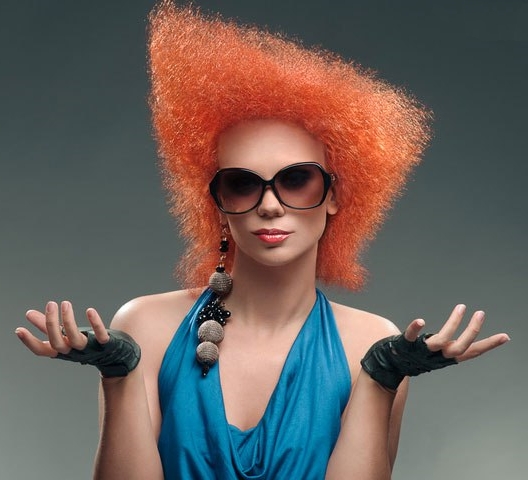 Carrot-colored curly hair in a frizzy, crazy asymmetrical punk rock look