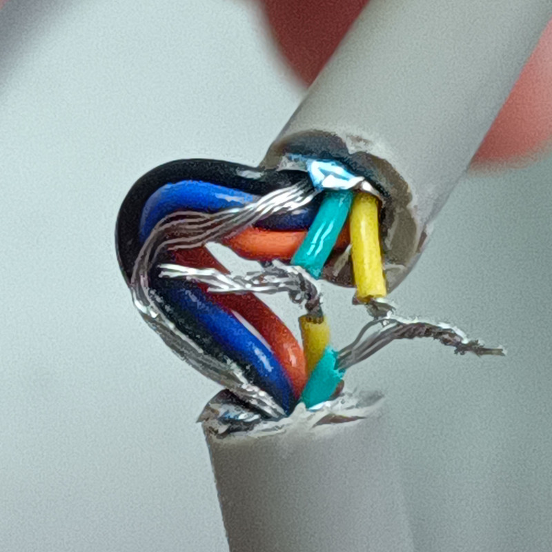 A serial cable with a section cut out, exposing its wires. Two of the wires have been severed and re-attached.