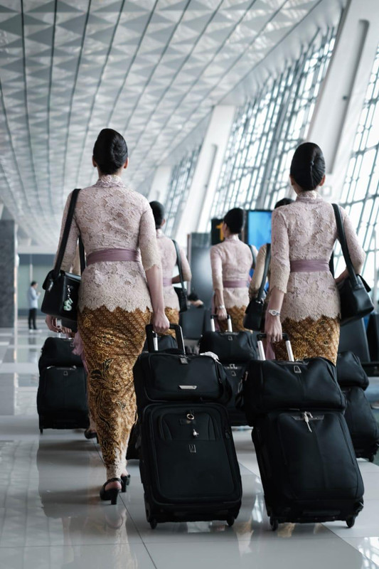 Pramugari Garuda Indonesia membawa koper mereka