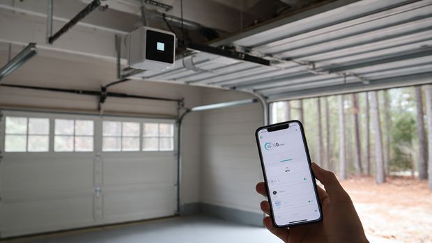 Modern smart garage door opener installed on residential garage ceiling with smartphone control
