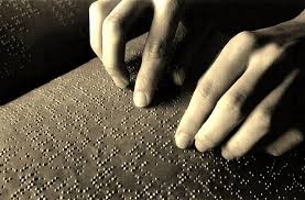 Blind African man reading braille book in comfortable setting