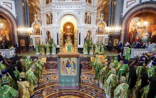 Orthodox priests and worshippers participating in a liturgical service inside a Kremlin cathedral
