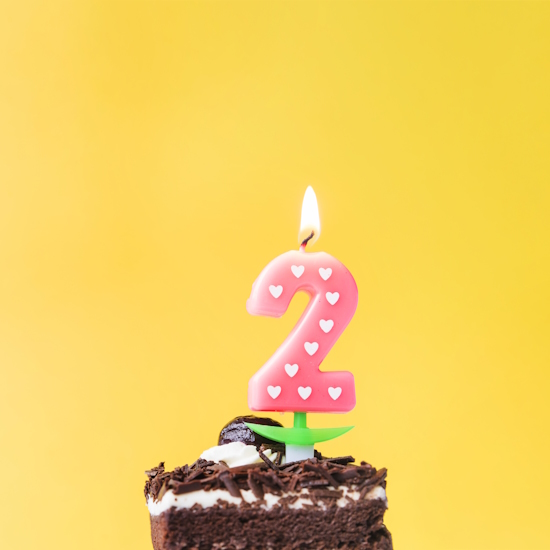 illuminated-love-two-year-candle-cake-slice-yellow-background.jpg