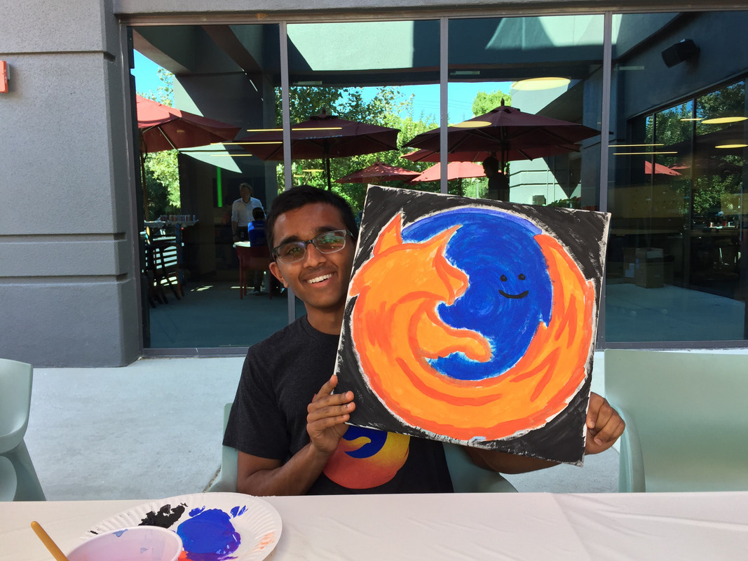 Me holding a painting that resembles the Firefox logo