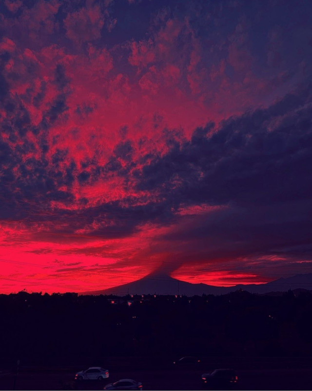 a photograph of a dark cloudy sky at sunset. the sky is bright red.