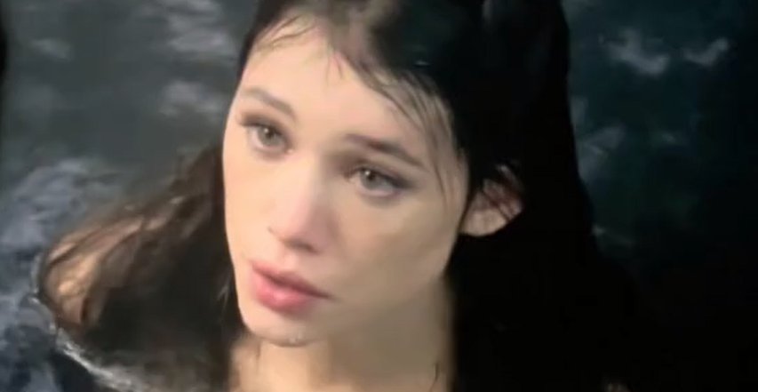 A hot girl who has her hair open and is showing her boobs.