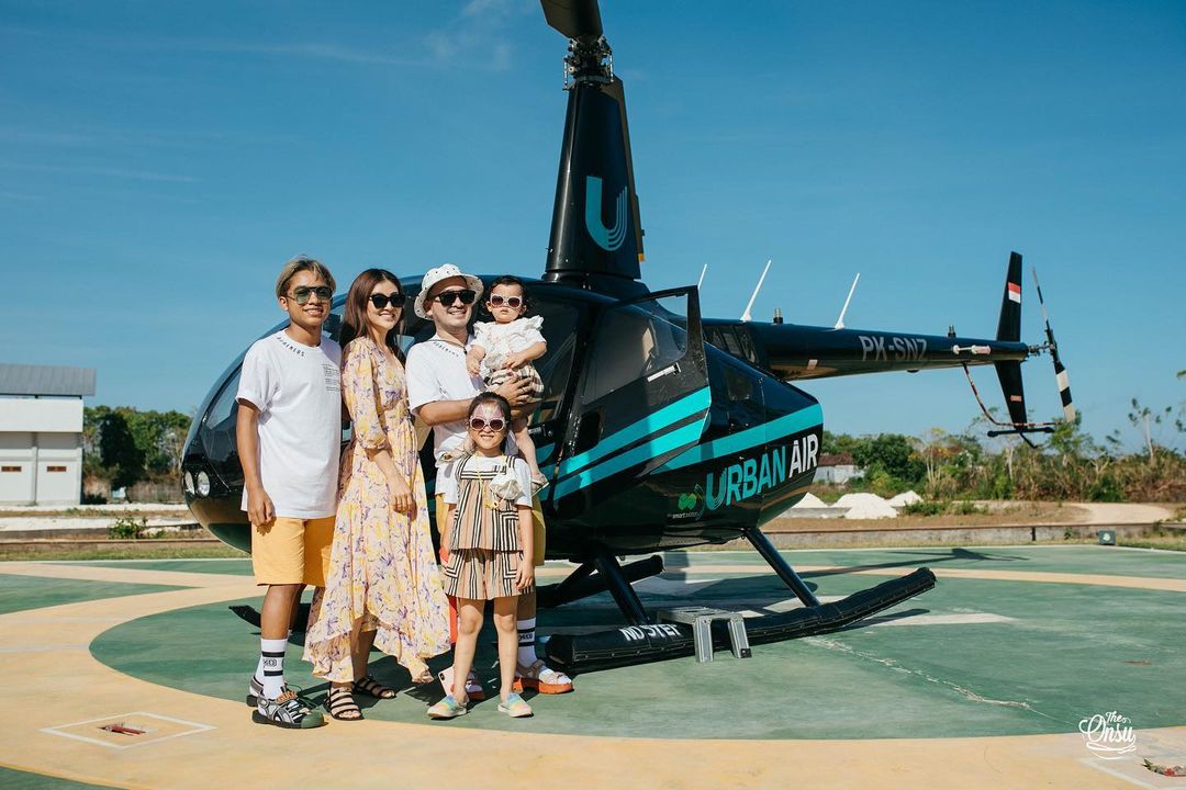 Sarwendah dan keluarga kecilnya saat berpose di samping helikopter yang mereka naiki.