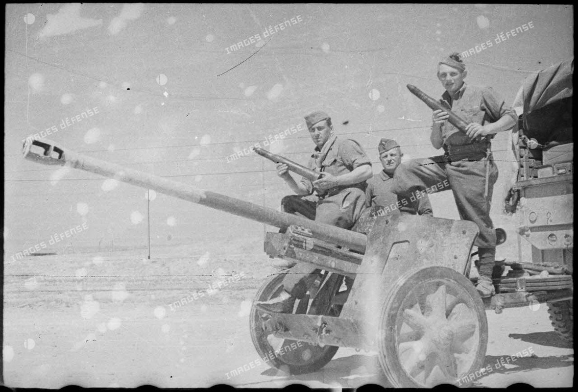 Des soldats du FSEA (Front du sud-est algérien) posent sur un canon antichar allemand Pak 38 de 5 cm