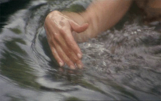 gif of a light-skinned human hand moving through water.