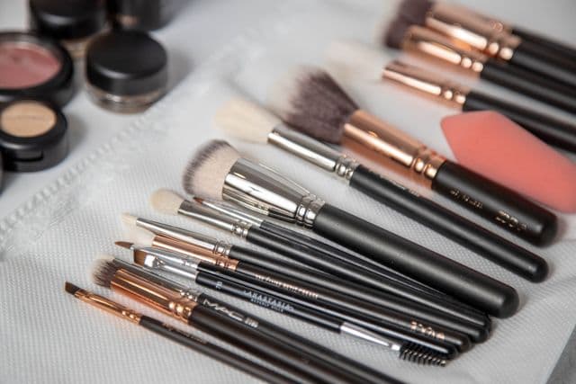 Clean makeup brushes laid flat on a white towel after washing 