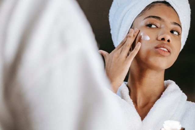 Woman applying skincare products as part of a simple skin barrier repair routine