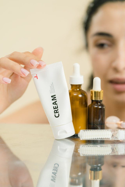a young woman seitching between skincare products before her skin can adopt to it. 