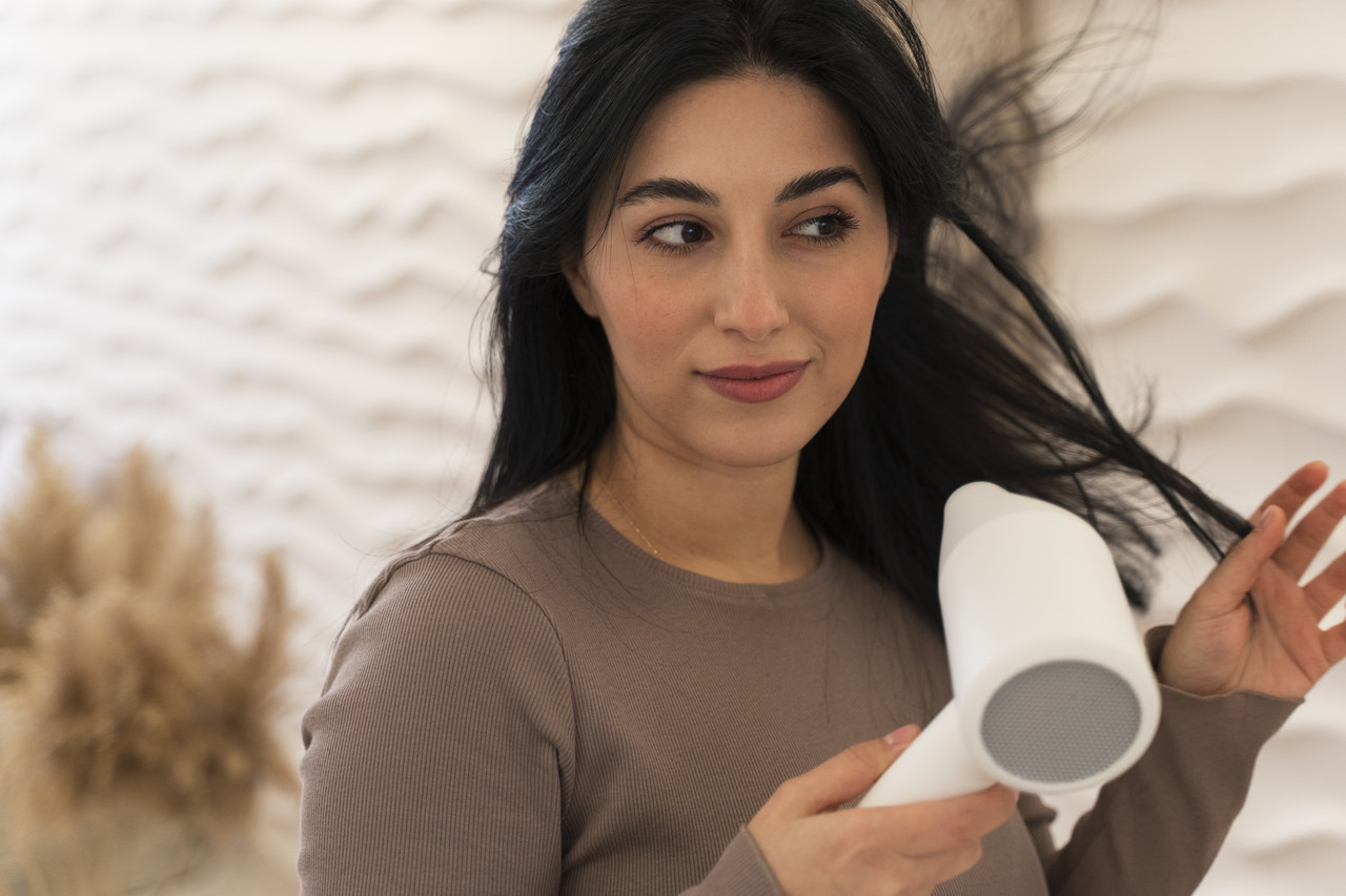 woman using hairdryer her beauty routine (1)