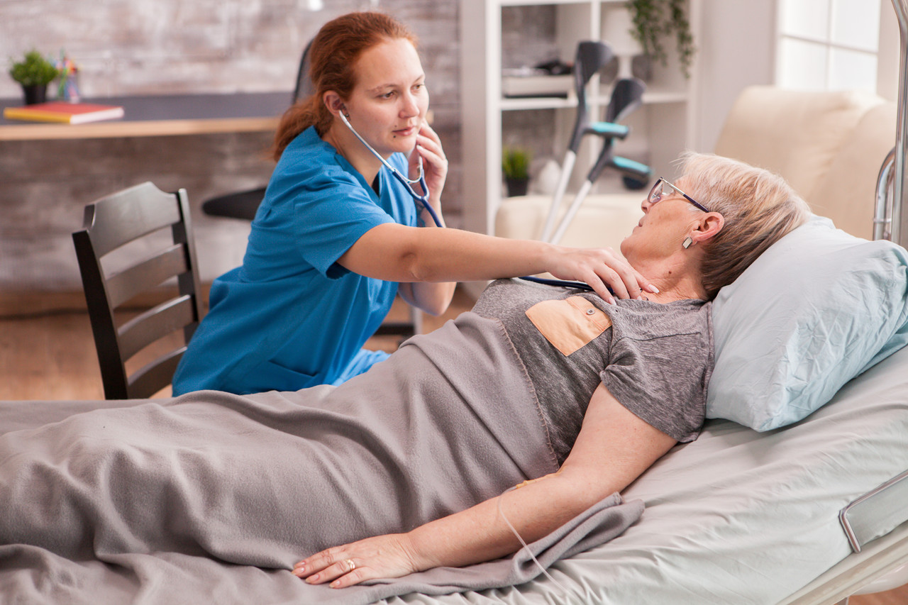 female doctor using stethoscope check old woman heart nursing home
