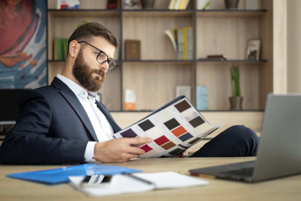side view man reading desk