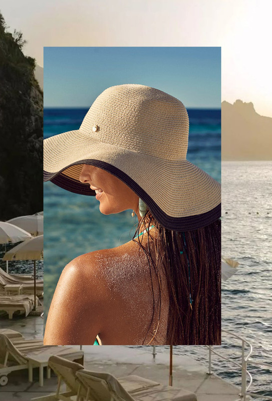 Mulher com chapéu de abas largas à beira-mar na Europa