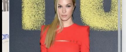 A Hot Girl Standing In A Red Dress, Showing Off Her Boobs.