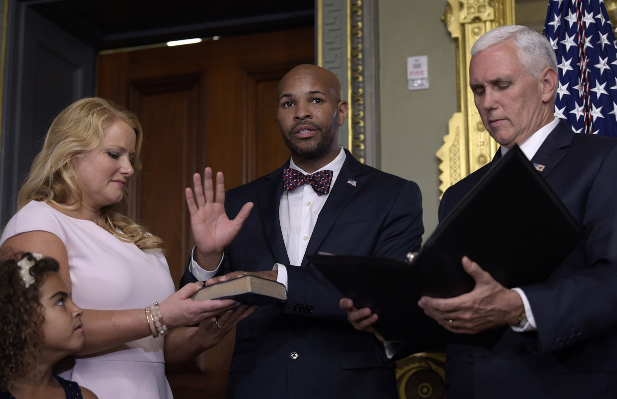 Vice President Mike Pence, right, swears in Dr. Jerome Adams, center, as the 20th U.S. Surgeon General with his wife Lacey and daughter Millie