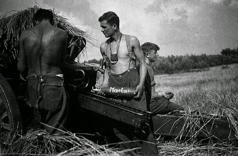 Varios servidores de un obús 10,5 cm leichte Feldhaubitze de la 4th SS Artillery, 4ª. SS-Polizei-Panzergrenadier-Division, se disponen a cargar un proyectil marcado con Marta Varios servidores de un obús 10,5 cm leichte Feldhaubitze de la 4th SS Artillery, 4ª. SS-Polizei-Panzergrenadier-Division, se disponen a cargar un proyectil marcado con Marta