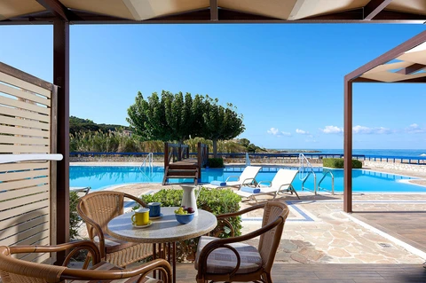 A villa terrace with a table set beside the pool