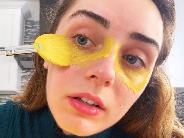 devojka maže pastu od kurkume na podočnjake