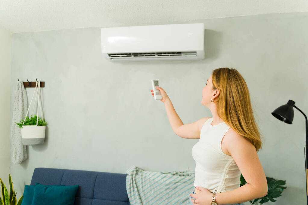 Homeowner Adjusting AC Temperature Remote