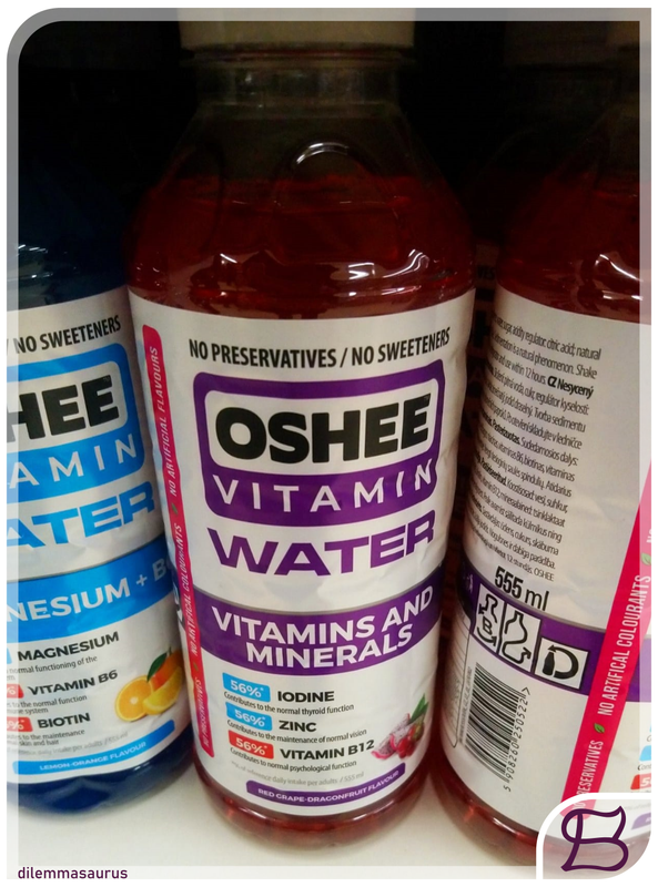 A photo of a drinks bottle amongst others on a supermarket shelf.  The label shows it is a bottle of 'Oshee Vitamin Water'.  A watermark shows it is the work of Dilemmasaurus