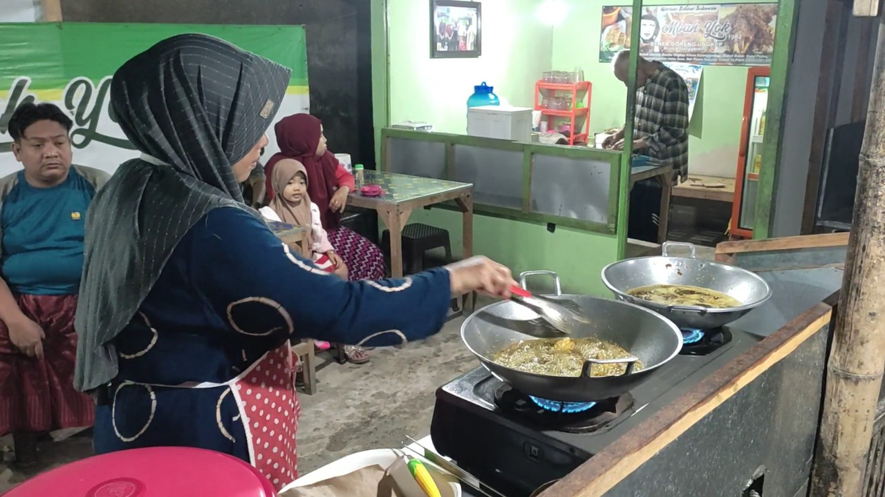 Istri Mbah Yok sedang membantu berjualan bebek goreng Rp 10 ribuan, tempat makan malam enak di Lamongan yang laris manis.