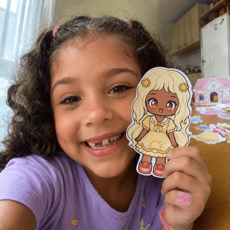 Menina mostrando bonecas de papel 1