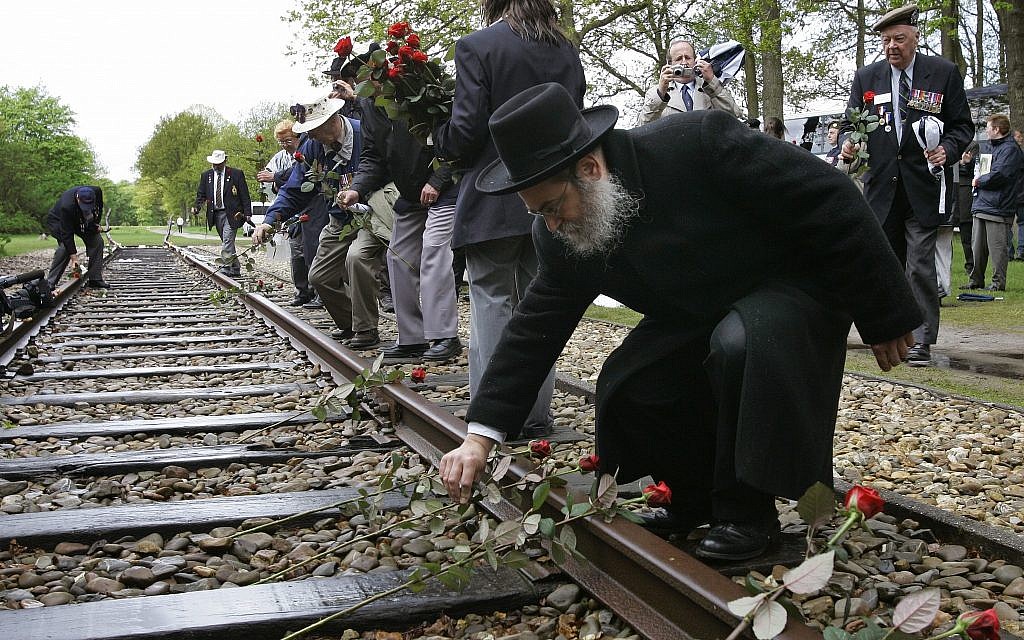 Un rabino coloca una rosa sobre las vías en el antiguo campo de concentración de Westerbork, Holanda, desde donde más de 100.000 judíos fueron transportados a campos de exterminio nazis. Foto de archivo del 9 de mayo de 2015. AP Foto-Peter Dejong