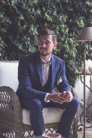 homme-costume-bleu-assis-mur-vegetal-mariage