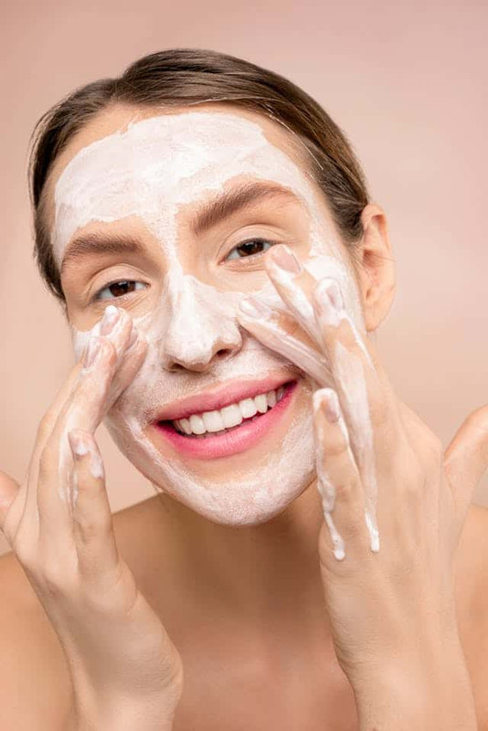 a woman washing her face with cleanser to identify her skin type, so know exactly which beginners skincare routine to follow 