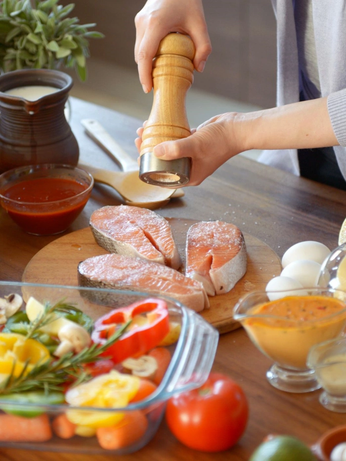 A woman is preparing fish in the kitchen