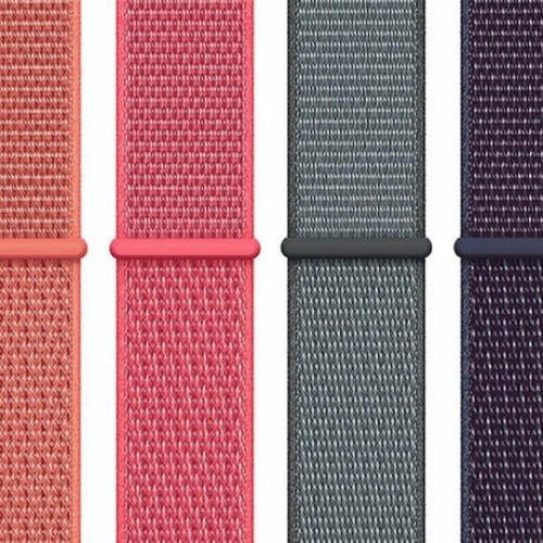 Apple Watch con correa de piel marrón combinada con un traje gris de cuadros y una manga de punto
