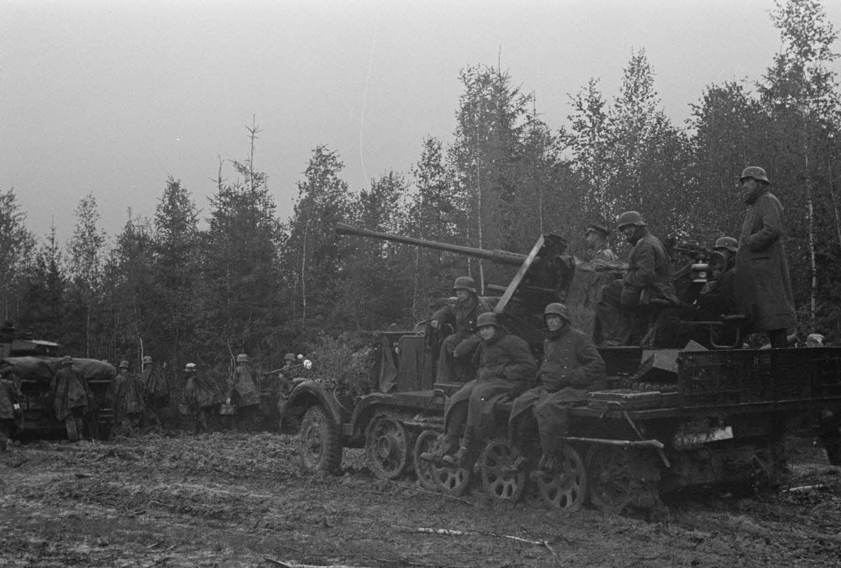 La progression de fantassins allemands soutenus par des blindés Panzer-III et un semi-chenillé Sd.kf