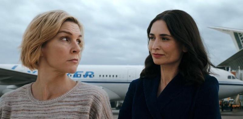 still frame from pluribus showing Carol and raban sharing a meaningful but silly glance