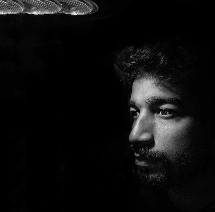 close up de um jovem pensativo olhando para longe contra um fundo preto 1048944 19053551